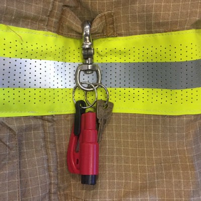 Red MiFire Glass breaker seatbelt cutter. Clipped to Fire Fighter jacket MiFire Australia